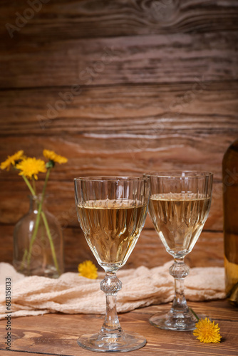 Glasses of dandelion wine on wooden table
