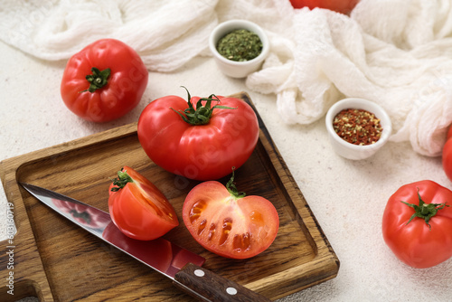 Wooden board with fresh tomatoes on white background