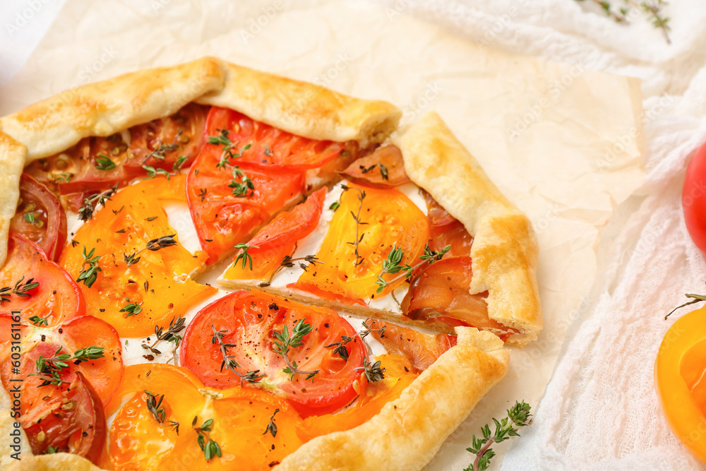 Baking paper with tasty tomato galette, closeup Baking paper with tasty tomato galette, closeup