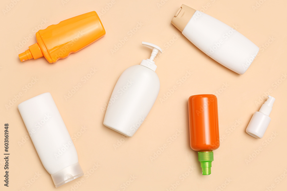 Different bottles of sunscreen cream on pale orange background Different bottles of sunscreen cream on pale orange background