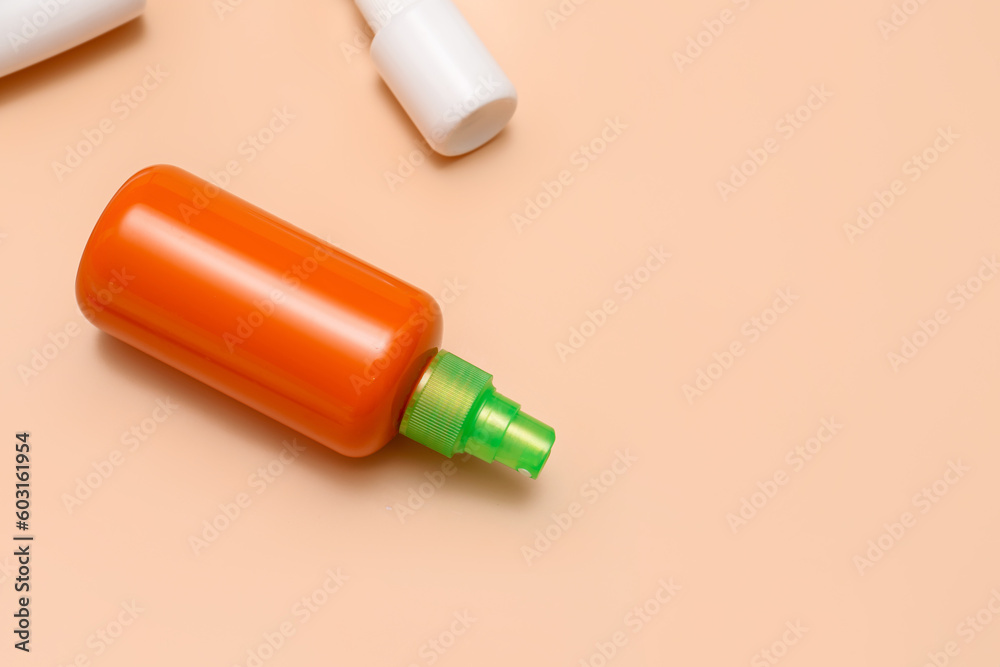 Different bottles of sunscreen cream on pale orange background Different bottles of sunscreen cream on pale orange background