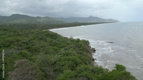 Flight along the coast of Palomino, Colombia on the Caribbean sea with waves hitting the shore and mountains in the background photo