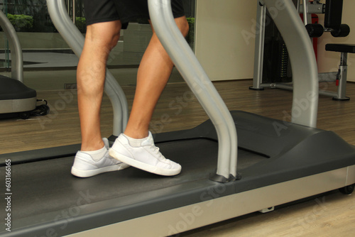 Forty-year-old dark-haired Latino adult man exercises his legs on the treadmill as a treatment for diseases such as tendonitis, tendon rupture or cruciate ligament injury