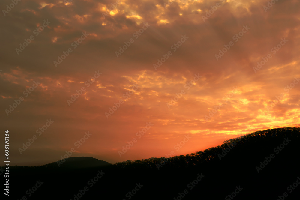 Beautiful sunrise on the mountain. Refreshing morning landscape with natural red-orange sun rays in summer.Holiday concept.