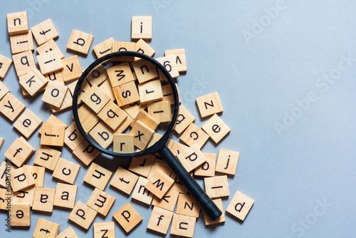 English alphabet made of square wooden tiles with the English alphabet scattered on blue background. The concept of thinking development,grammar.