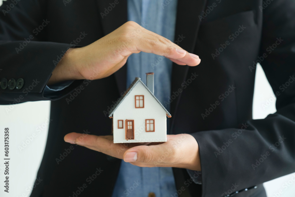 Close up real estate agent holding house model for consult the client. Close up real estate agent holding house model for consult the client.