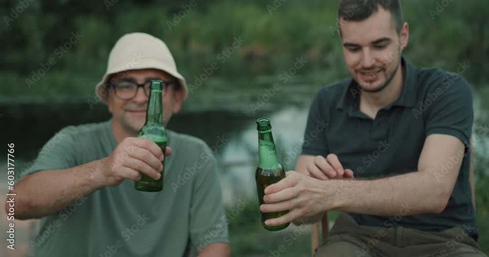 Male friends fishing and drinking beer on lake Male friends fishing and drinking beer on lake