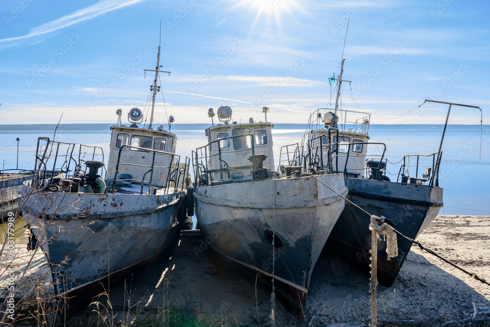 View of three old rusty fishing vessels pulled ashore