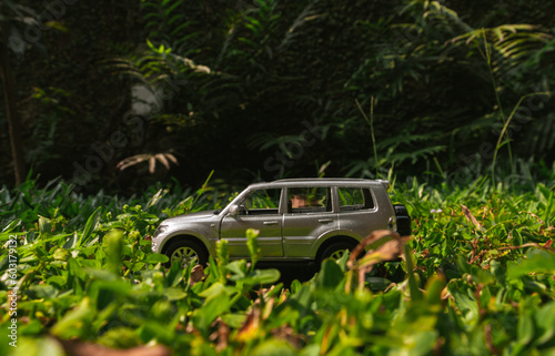 Concept for travelling with an SUV car. Photo of a toy car placed on the grass, after some edits. © Figan