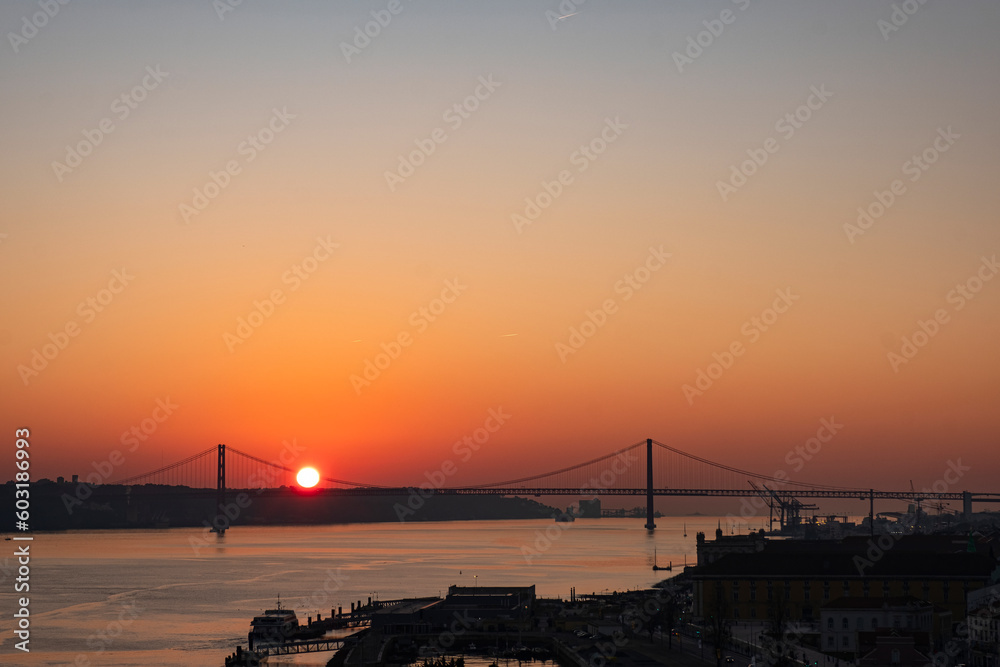 View of the Tagus river and Ponte 25 de Abril bridge at sunset. Lisbon. Portugal.