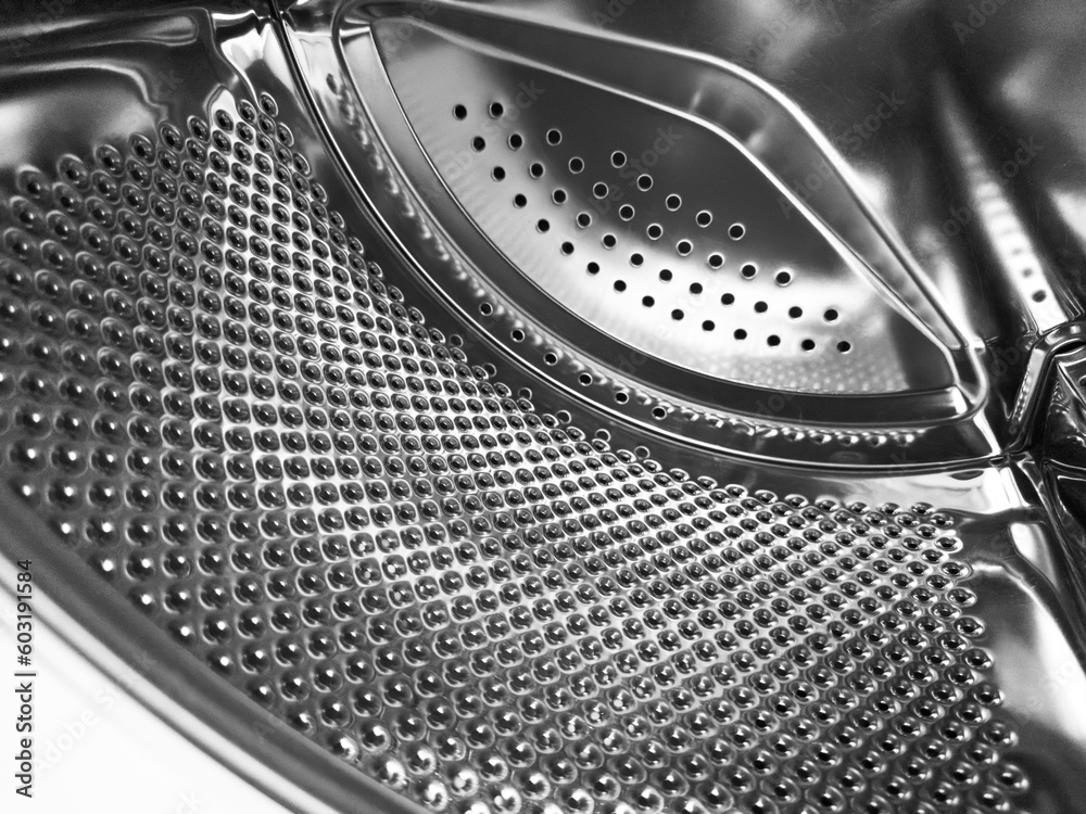 Washing machine drum close up. Washing machine background. Inside the washing machine. Metal
