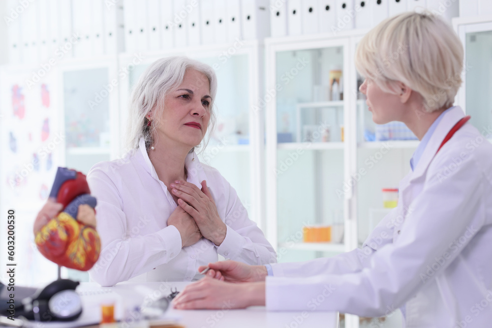 Woman patient puts hands on chest complaining about pain