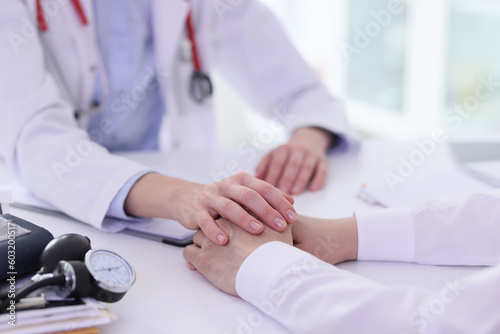 Doctor holds client hands during consultation in clinic
