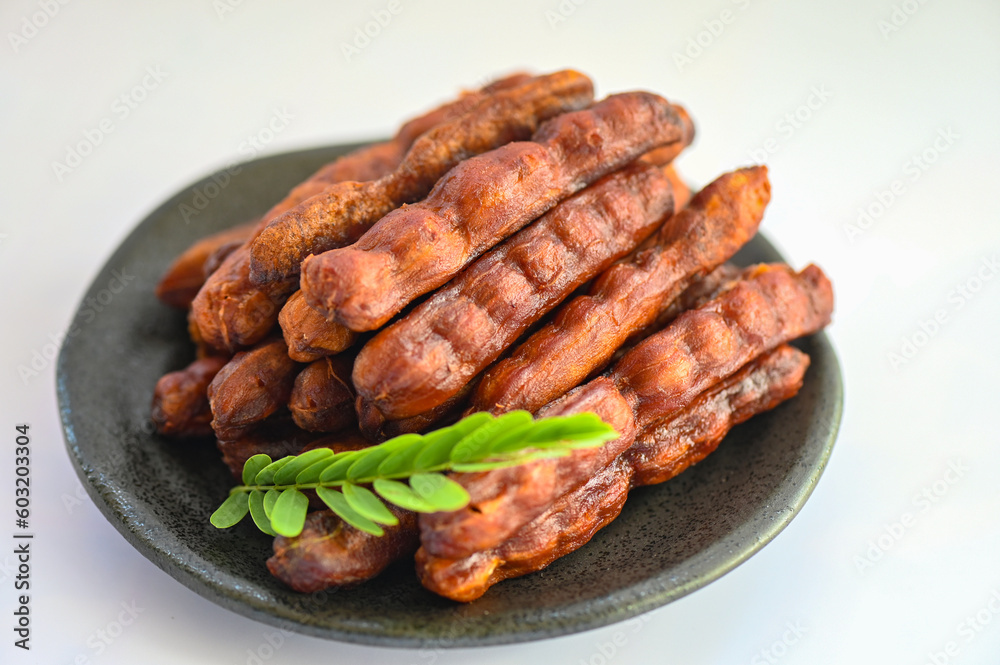 Tamarind sweet for food fruit ripe tamarinds on plate and white background, Tamarind peel tropical fruits summer Tamarind sweet for food fruit ripe tamarinds on plate and white background, Tamarind peel tropical fruits summer