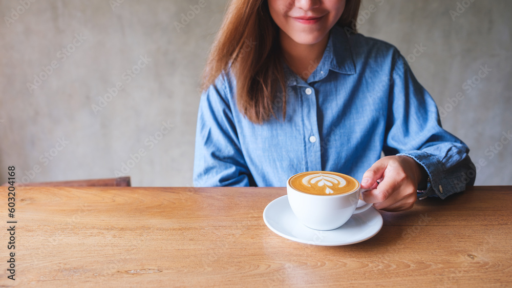 Closeup image of a young woman holding and drinking hot coffee Closeup image of a young woman holding and drinking hot coffee