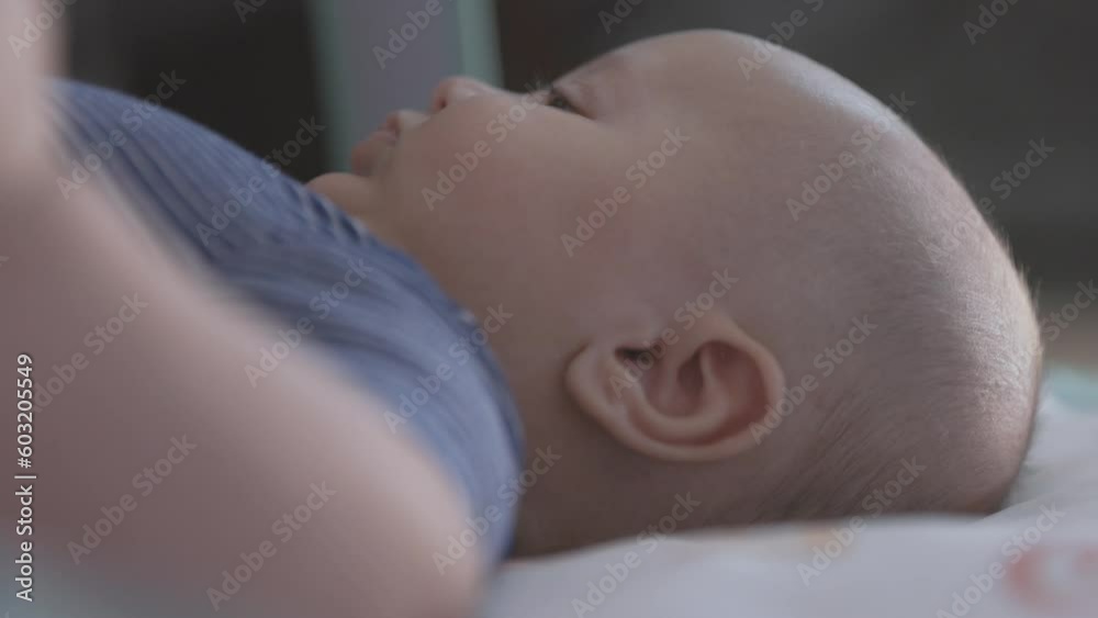 3 Month Old Baby On Back Low Angle Side Profile. slow motion view side profile of a 3 month old baby as he looks around 3 Month Old Baby On Back Low Angle Side Profile. slow motion view side profile of a 3 month old baby as he looks around