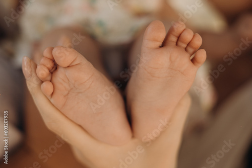 Tiny baby feet in a perents hands. Family and home concept. Healthcare, pediatrics. Cozy morning at home. Motherhood