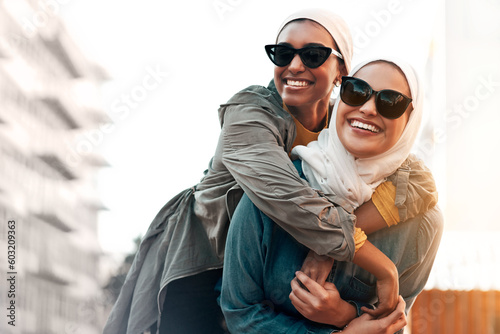 Muslim woman, friends and piggyback in city with freedom, youth and urban travel together in Qatar. Islamic women, happiness and walking in metro with funny game, sunglasses and comic journey