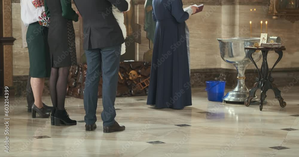 Process of baptizing child in church. Godparents hold child in their