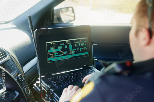 Foto Database, laptop and a police officer in a car for security, urban law and safety data while working
