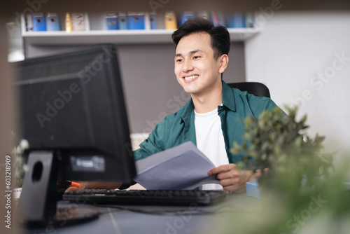 Photo of young Asian businessman working at office