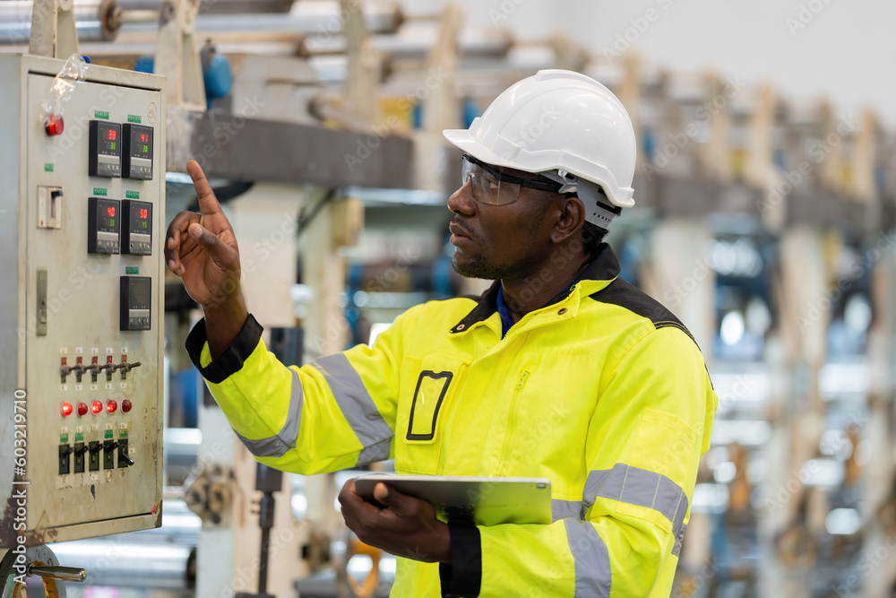 african engineer He is pointing his finger at the control board. Wear ...