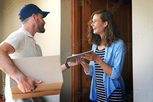Happy woman, delivery man and box with tablet at door for order, parcel or cargo in transport service. Female person receiving shipment from male courier, supply chain or ecommerce purchase at home photo
