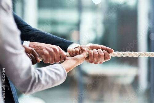 Hands, teamwork and rope with business people grabbing during a game of tug of war in the office. Collaboration, help or strength with a team of employees or colleagues pulling an opportunity at work photo