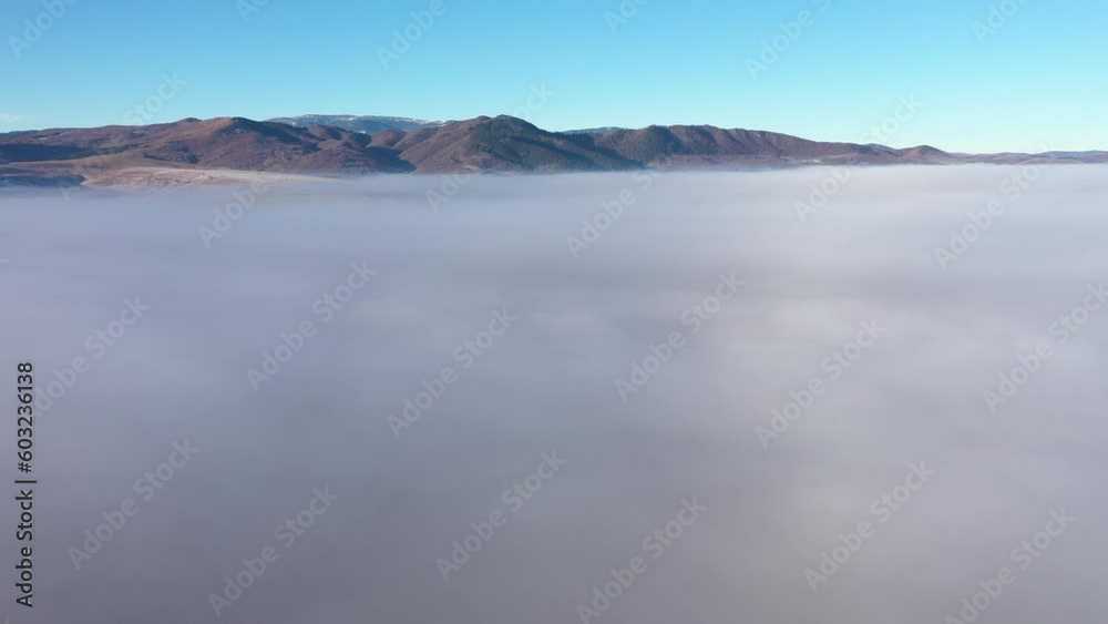 Aerial drone view over mist and clouds in a sunny morning during sunrise Aerial drone view over mist and clouds in a sunny morning during sunrise