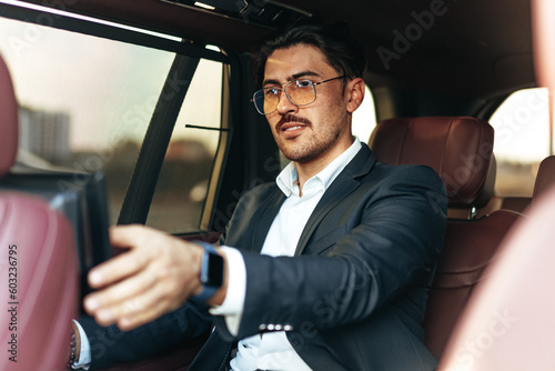 Young elegant businessman watching TV on the screen in luxury car © fotofabrika