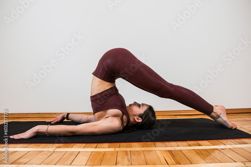Young caucasian fit woman practicing yoga at home
