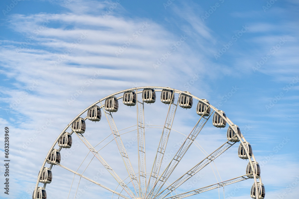 Fototapeta premium A view of a the top half of a Ferris Wheel against to cloudy sky.
