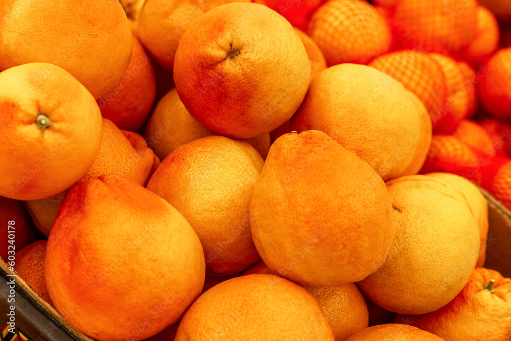 Lots of fresh large grapefruits on the counter in the store. Organic food, vitamins and health. Close-up. Lots of fresh large grapefruits on the counter in the store. Organic food, vitamins and health. Close-up.