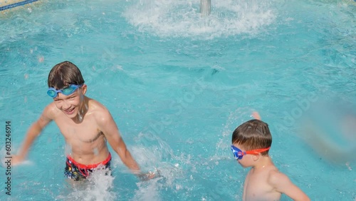 Happy children pool fun splash water happy summer kids splashing in pool kids holiday summer travel fun boy. Cheerful children swimming pool playing water kids swimming boy water fun summer vacation