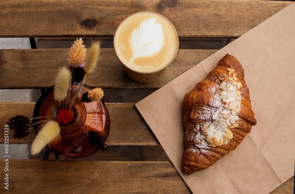morning homemade croissant with cup of coffee on wooden table, cozy breakfast top view, spikelet of wheat decor