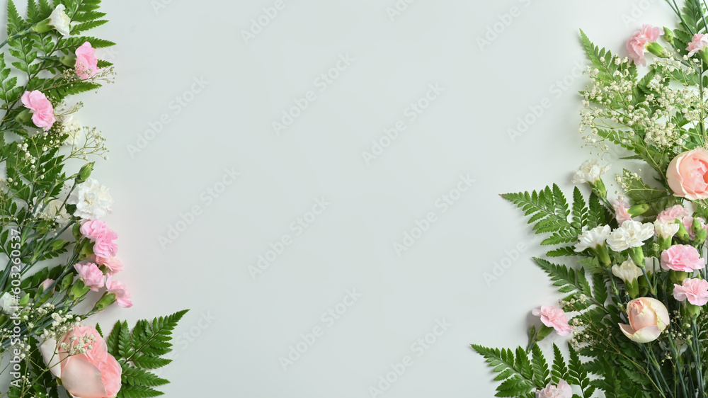 Beautiful floral frame of fresh flowers with pink rose, carnation and fern leaves with copy space for text on blue background Beautiful floral frame of fresh flowers with pink rose, carnation and fern leaves with copy space for text on blue background