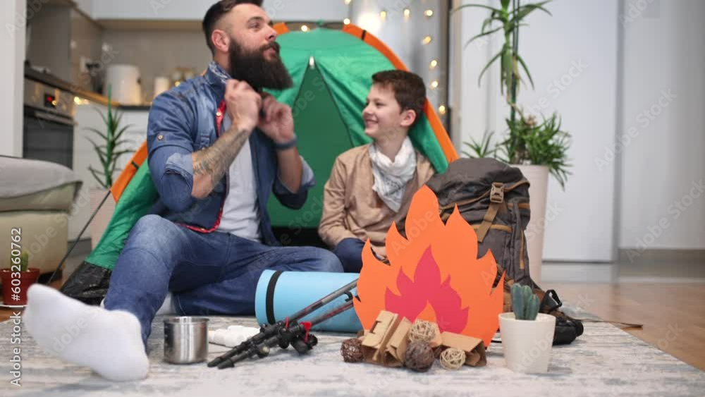 Father and son playing and having fun with camping tent in their living room. Lifestyle a new normal for social distancing in coronavirus outbreak situation Father and son playing and having fun with camping tent in their living room. Lifestyle a new normal for social distancing in coronavirus outbreak situation