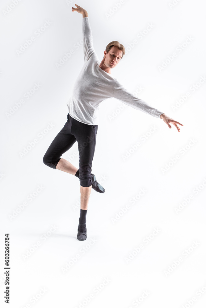 Caucasian Handsome Young Man Dancing Ballet Posing in Dance Pose with Lifted hands in White Shirt On White