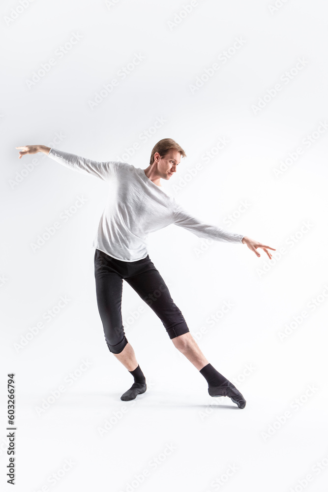 Caucasian Handsome Young Man Dancing Ballet Posing in Ballet Pose with Lifted Hands in White Shirt On White.