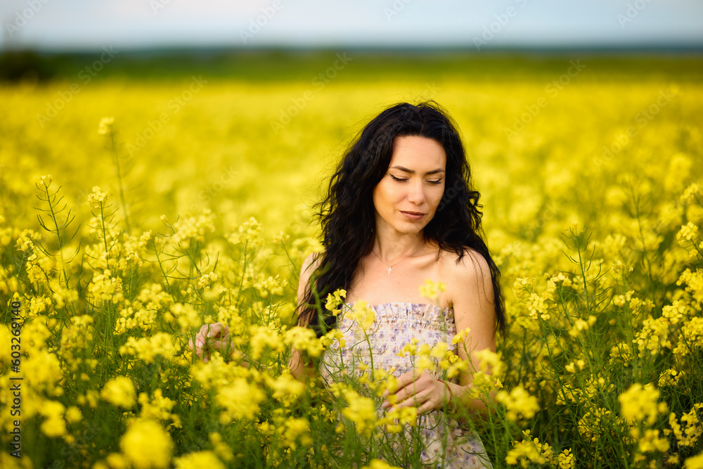 portrait of a brunette woman in a rapeseed field in spring portrait of a brunette woman in a rapeseed field in spring