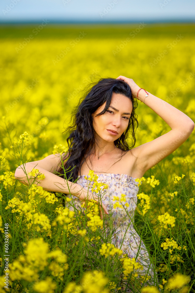 portrait of a brunette woman in a rapeseed field in spring portrait of a brunette woman in a rapeseed field in spring