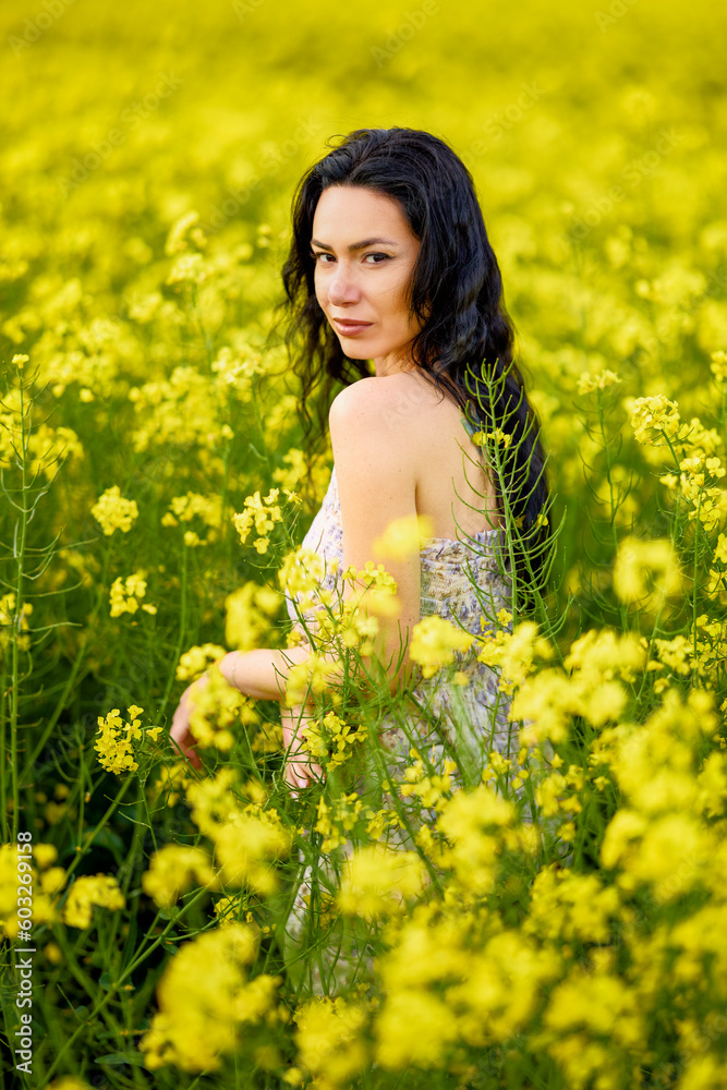 portrait of a brunette woman in a rapeseed field in spring portrait of a brunette woman in a rapeseed field in spring