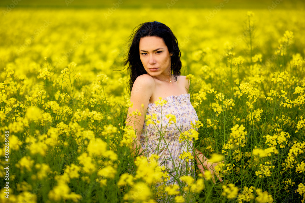portrait of a brunette woman in a rapeseed field in spring portrait of a brunette woman in a rapeseed field in spring