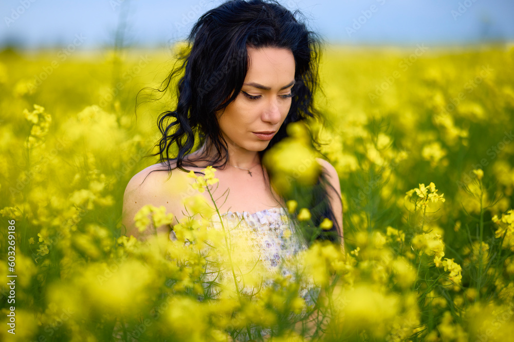 portrait of a brunette woman in a rapeseed field in spring portrait of a brunette woman in a rapeseed field in spring