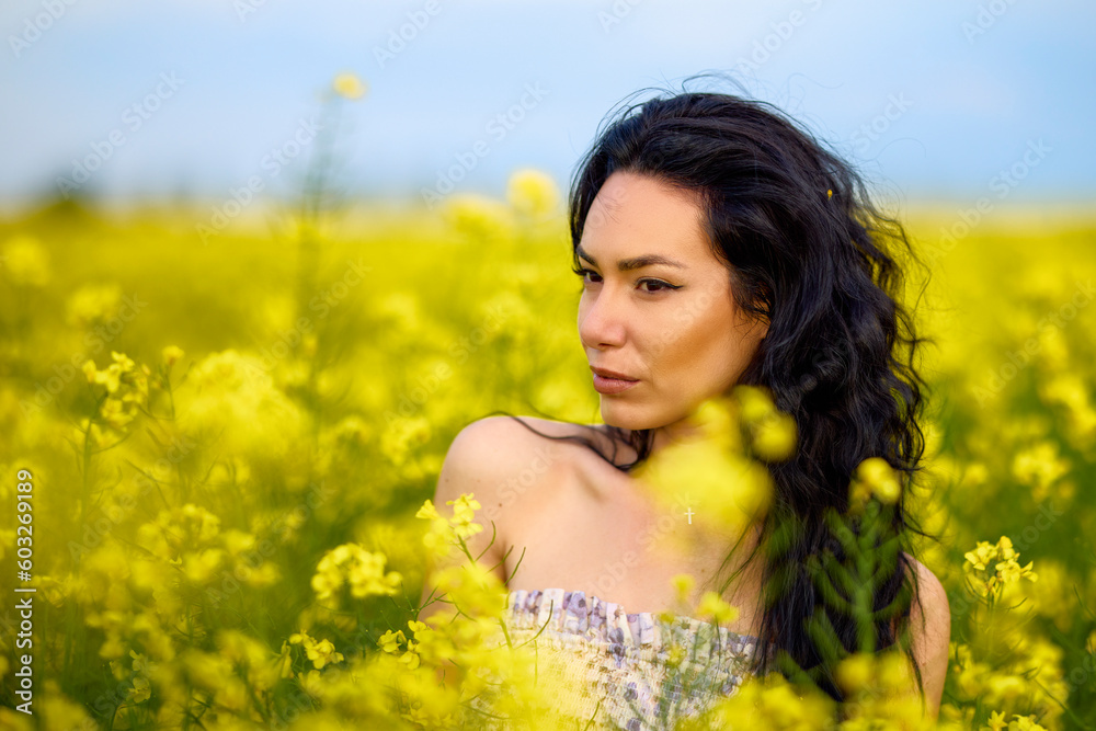 portrait of a brunette woman in a rapeseed field in spring portrait of a brunette woman in a rapeseed field in spring