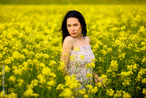 portrait of a brunette woman in a rapeseed field in spring © czamfir