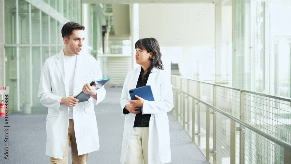 Multinational group walking in the lobby wearing white coats. Multinational group walking in the lobby wearing white coats.