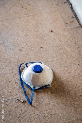 Protection mask for civil construction. Mask thrown to the ground after being used. photo