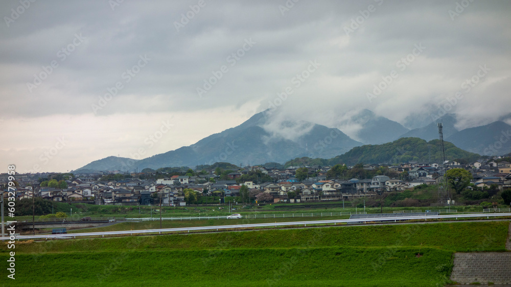 Fototapeta premium 雨上がりの皿倉山と帆柱山を覆う雲を遠賀川側から見る