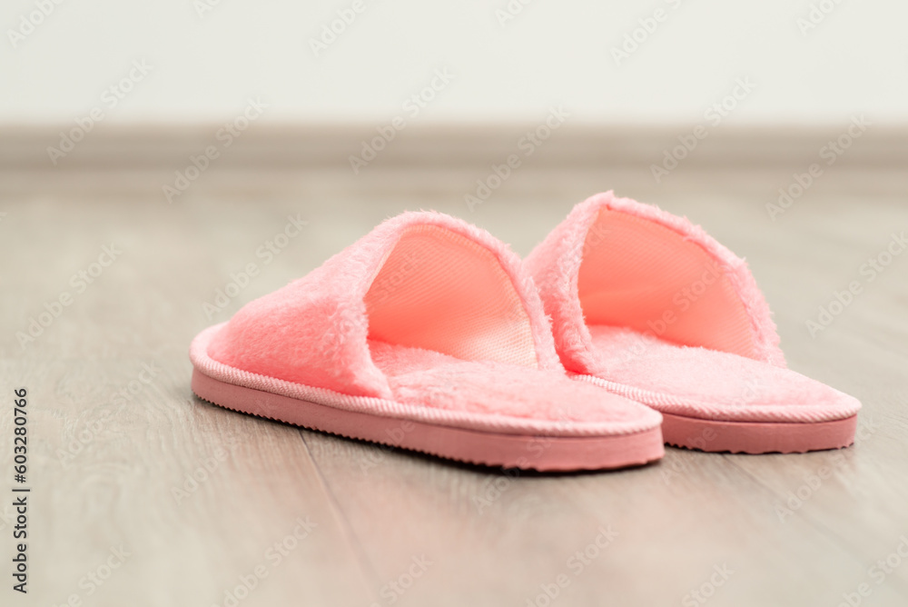 Pink home shoes on the floor. Slippers of pink colour in the room Pink home shoes on the floor. Slippers of pink colour in the room